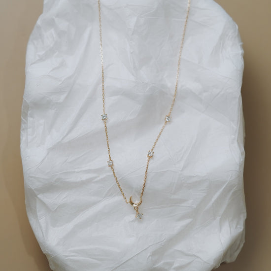 Dainty gold crescent moon necklace with sparkling moissanite stations