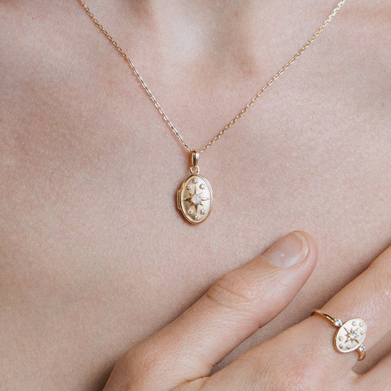 Gold oval opal locket necklace with celestial compass star and moissanite details
