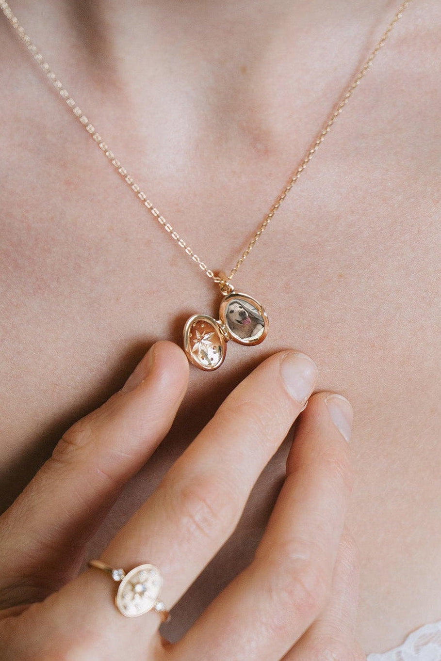 Gold oval opal locket necklace with celestial compass star and moissanite details