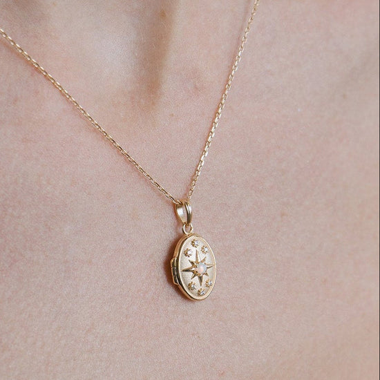 Gold oval opal locket necklace with celestial compass star and moissanite details