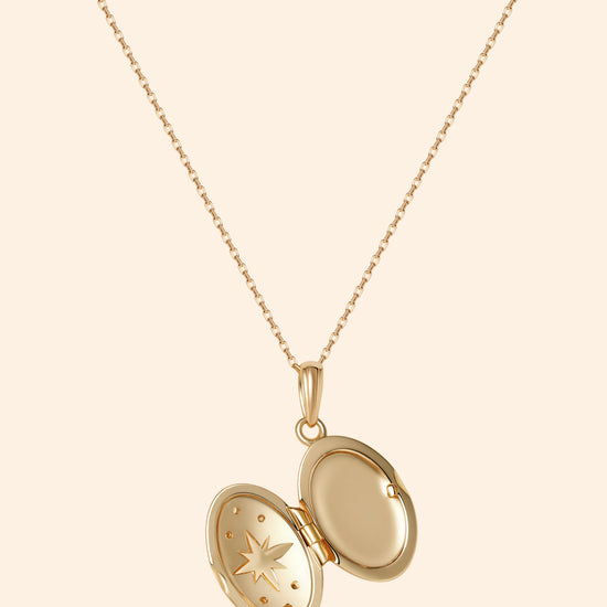 Gold oval opal locket necklace with celestial compass star and moissanite details