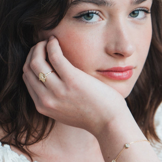 Dainty gold celestial compass ring with oval starburst design and sparkling accents