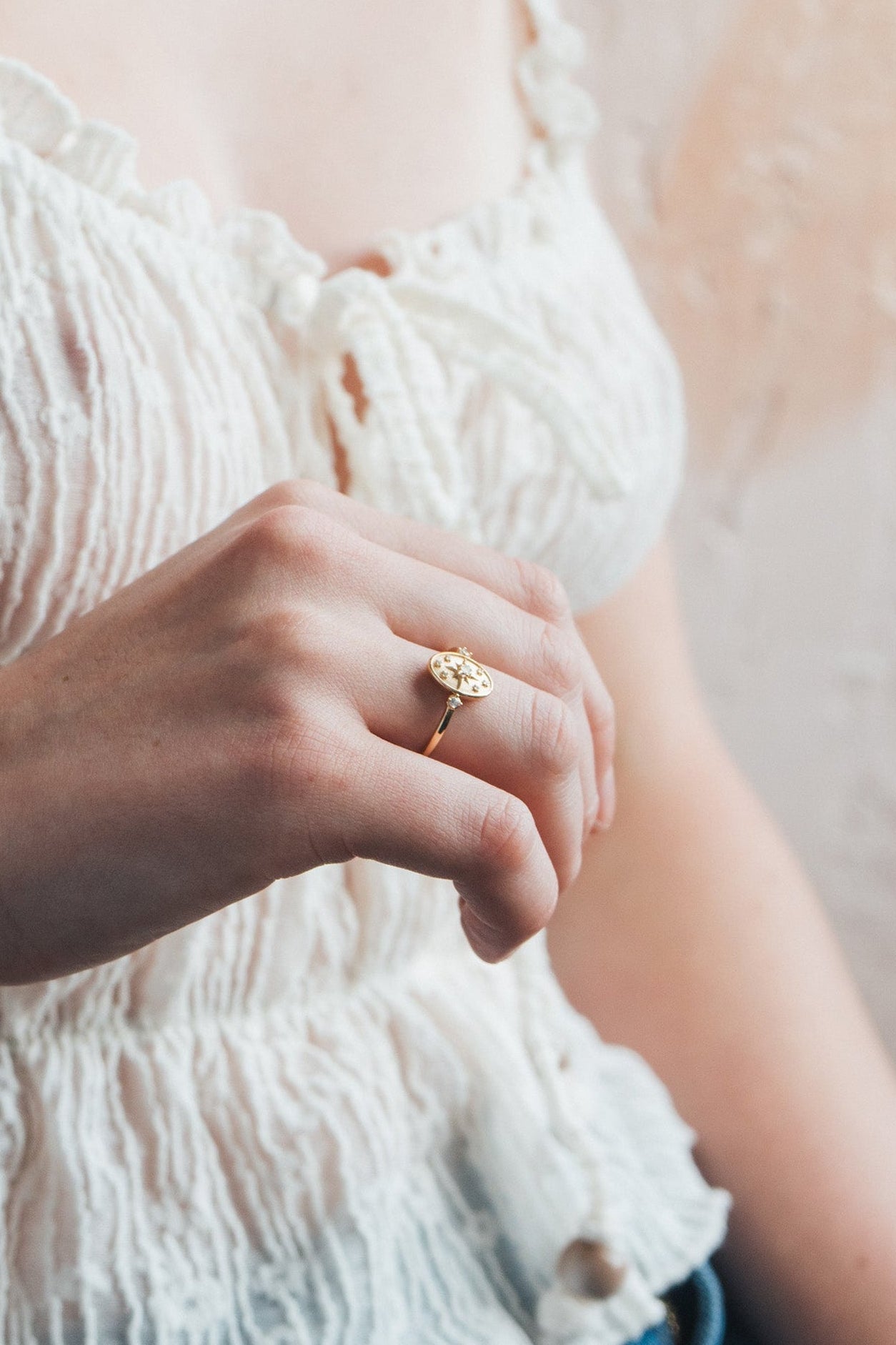 Dainty gold celestial compass ring with oval starburst design and sparkling accents