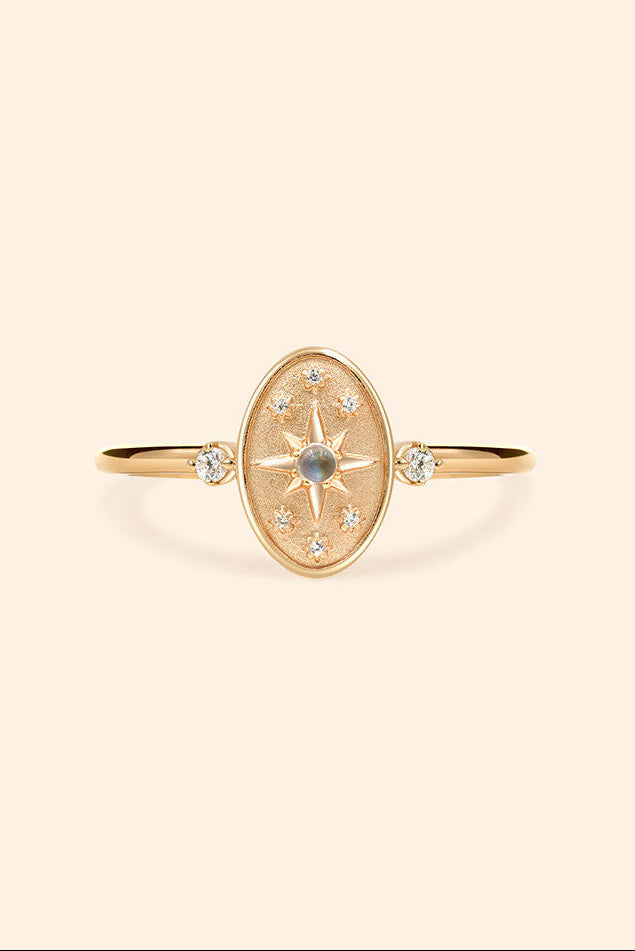 Dainty gold celestial compass ring with oval starburst design and sparkling accents