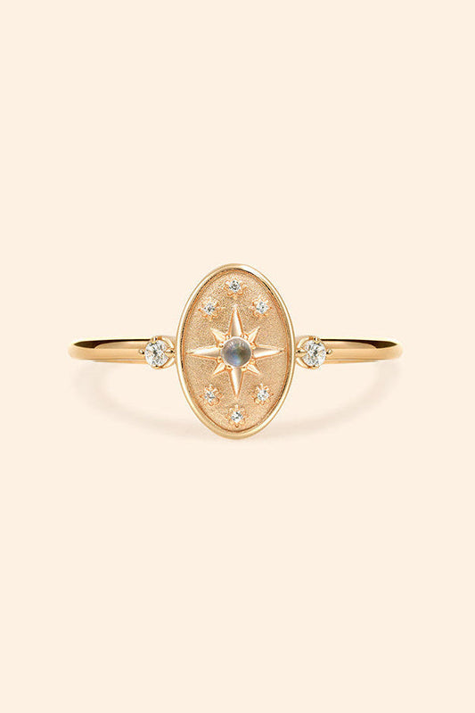 Dainty gold celestial compass ring with oval starburst design and sparkling accents