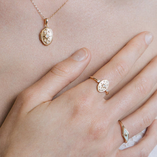 Dainty gold celestial compass ring with oval starburst design and sparkling accents