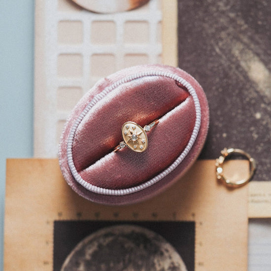 Dainty gold celestial compass ring with oval starburst design and sparkling accents