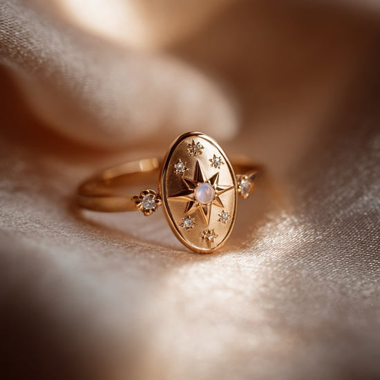 Dainty gold celestial compass ring with oval starburst design and sparkling accents