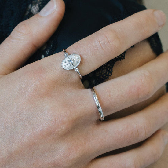 Dainty silver celestial compass ring with oval starburst design and sparkling accents