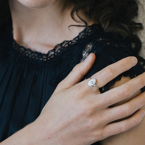 Dainty silver celestial compass ring with oval starburst design and sparkling accents
