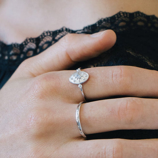 Dainty silver celestial compass ring with oval starburst design and sparkling accents