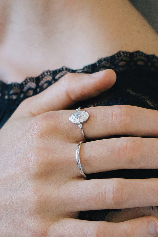 Dainty silver celestial compass ring with oval starburst design and sparkling accents