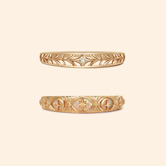 Two gold celestial stacking rings featuring iridescent opal star details and a center moissanite