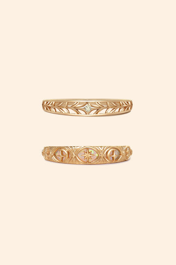 Two gold celestial stacking rings featuring iridescent opal star details and a center moissanite