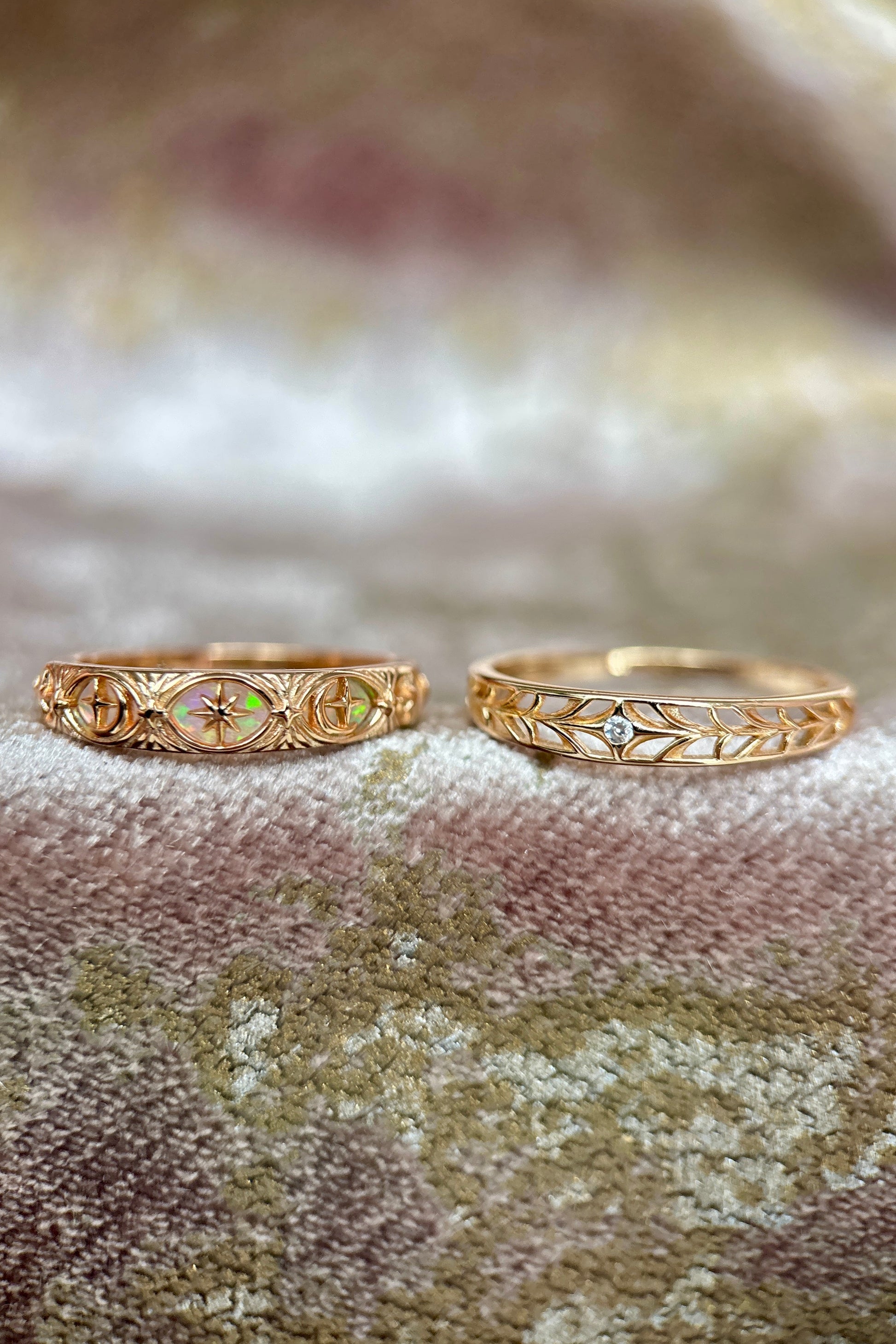 Two gold celestial stacking rings featuring iridescent opal star details and a center moissanite