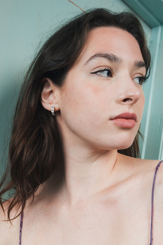 Silver solstice hoop earrings featuring fire opals and celestial starburst engravings by LIRAE.