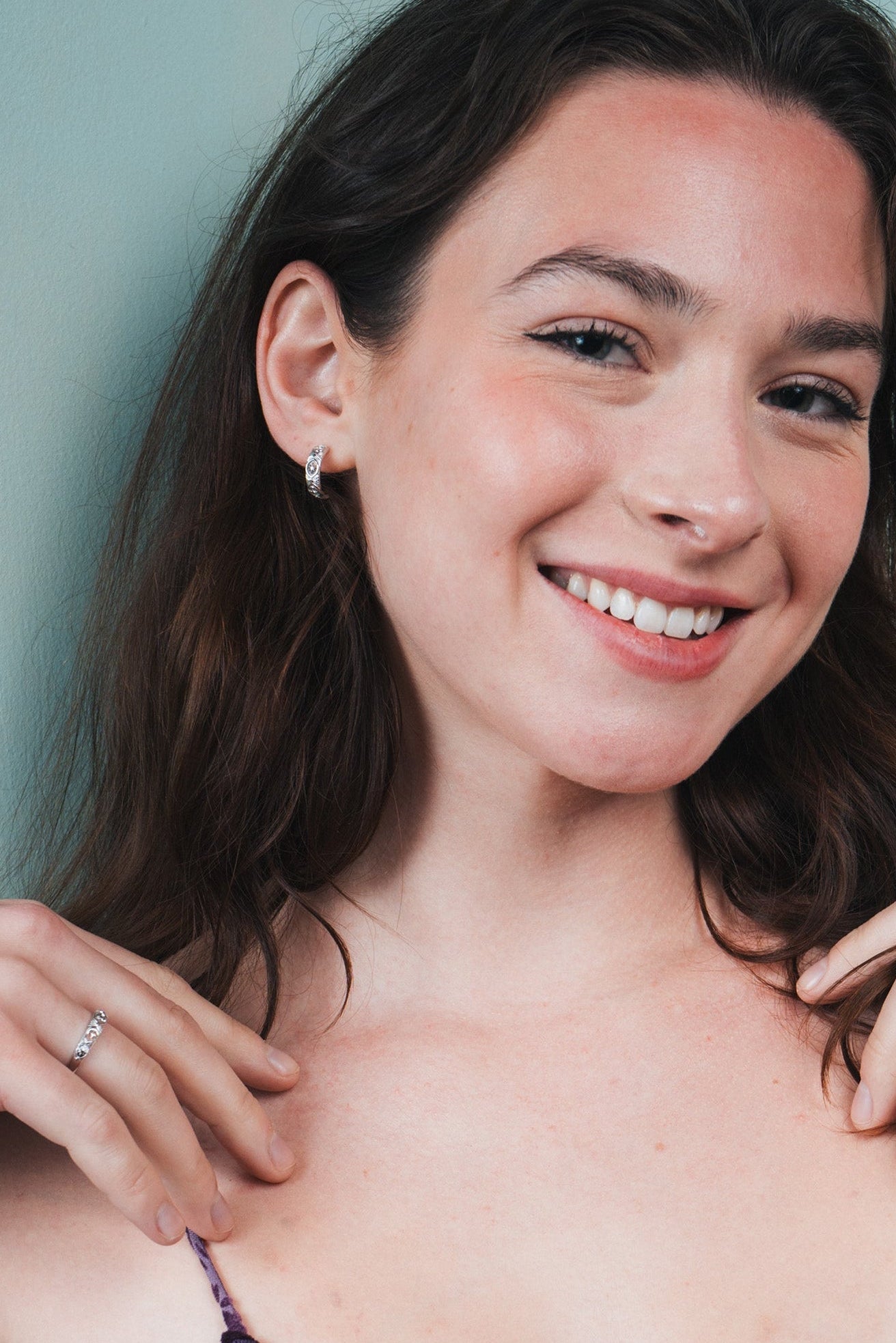 Silver solstice hoop earrings featuring fire opals and celestial starburst engravings by LIRAE.