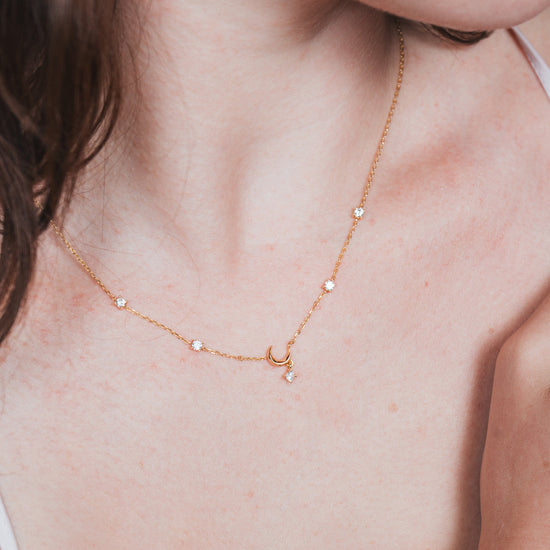 Dainty gold crescent moon necklace with sparkling moissanite stations