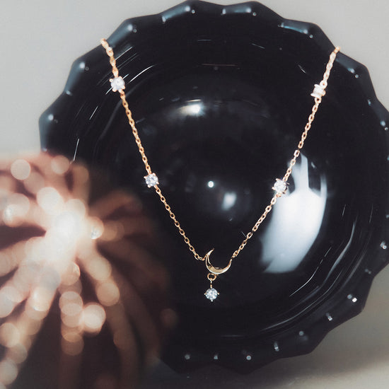 Dainty gold crescent moon necklace with sparkling moissanite stations