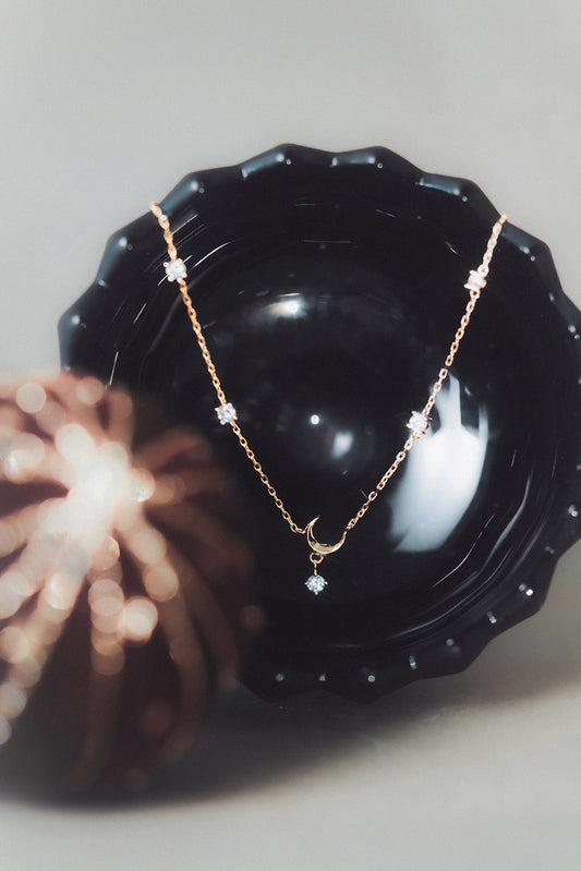 Dainty gold crescent moon necklace with sparkling moissanite stations