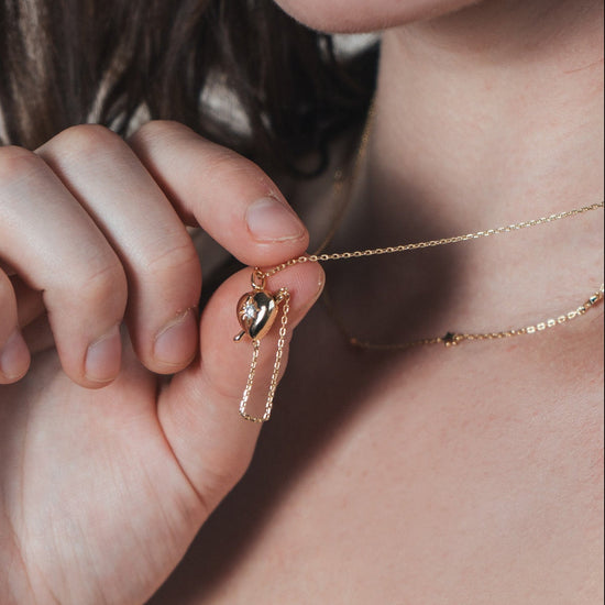 Gold heart arrow necklace with removable arrow and sparkling center moissanite stone