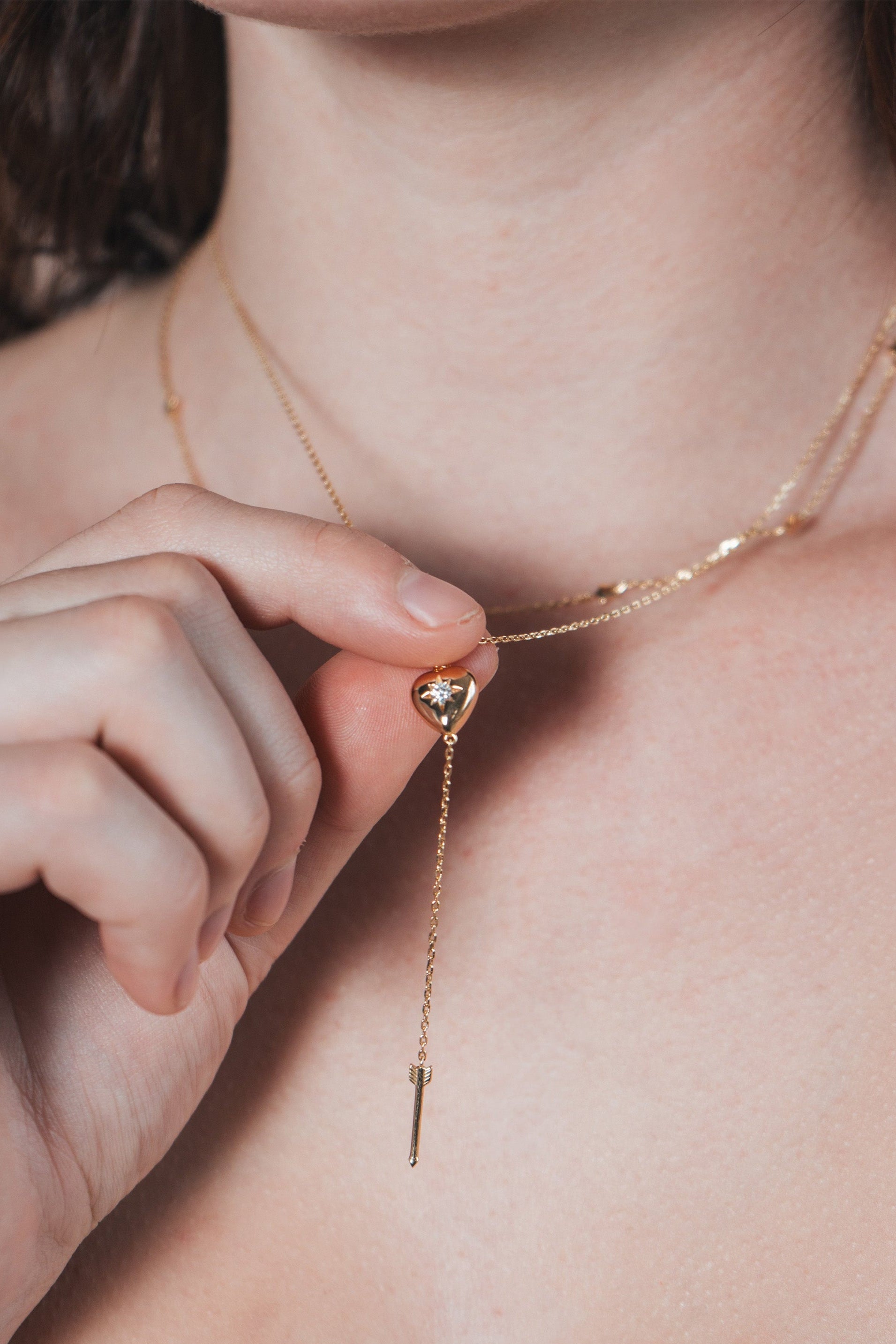 Gold heart arrow necklace with removable arrow and sparkling center moissanite stone