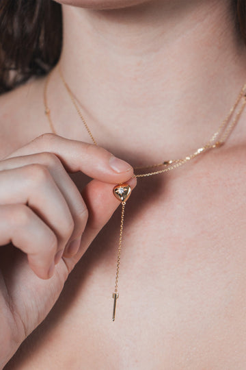 Gold heart arrow necklace with removable arrow and sparkling center moissanite stone