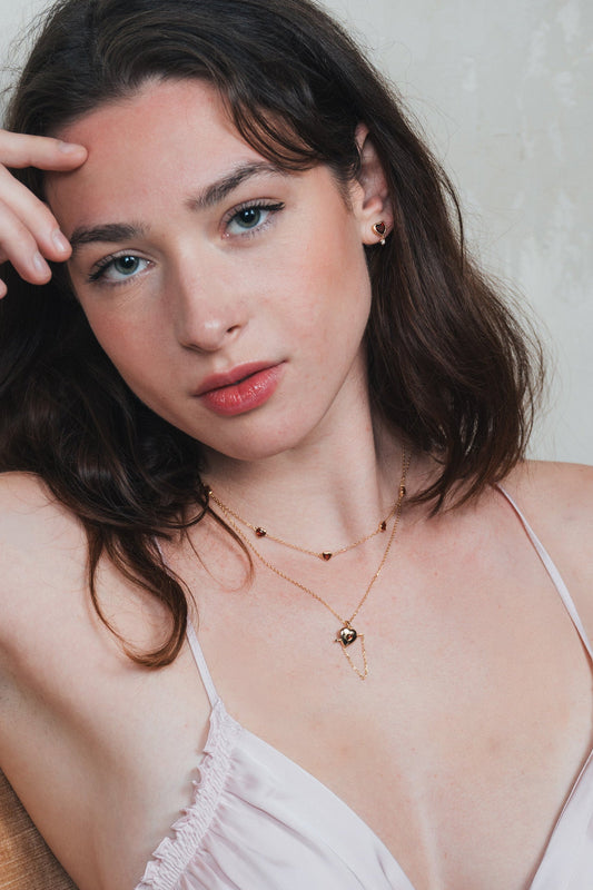 Gold heart charm necklace with removable arrow and red heart garnet center stone
