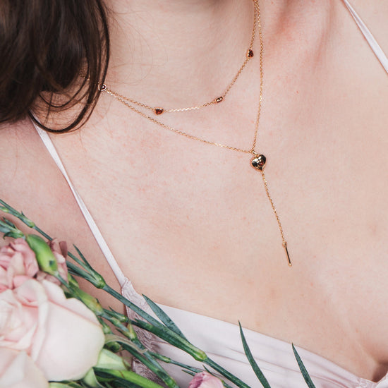 Gold heart charm necklace with removable arrow and red heart garnet center stone