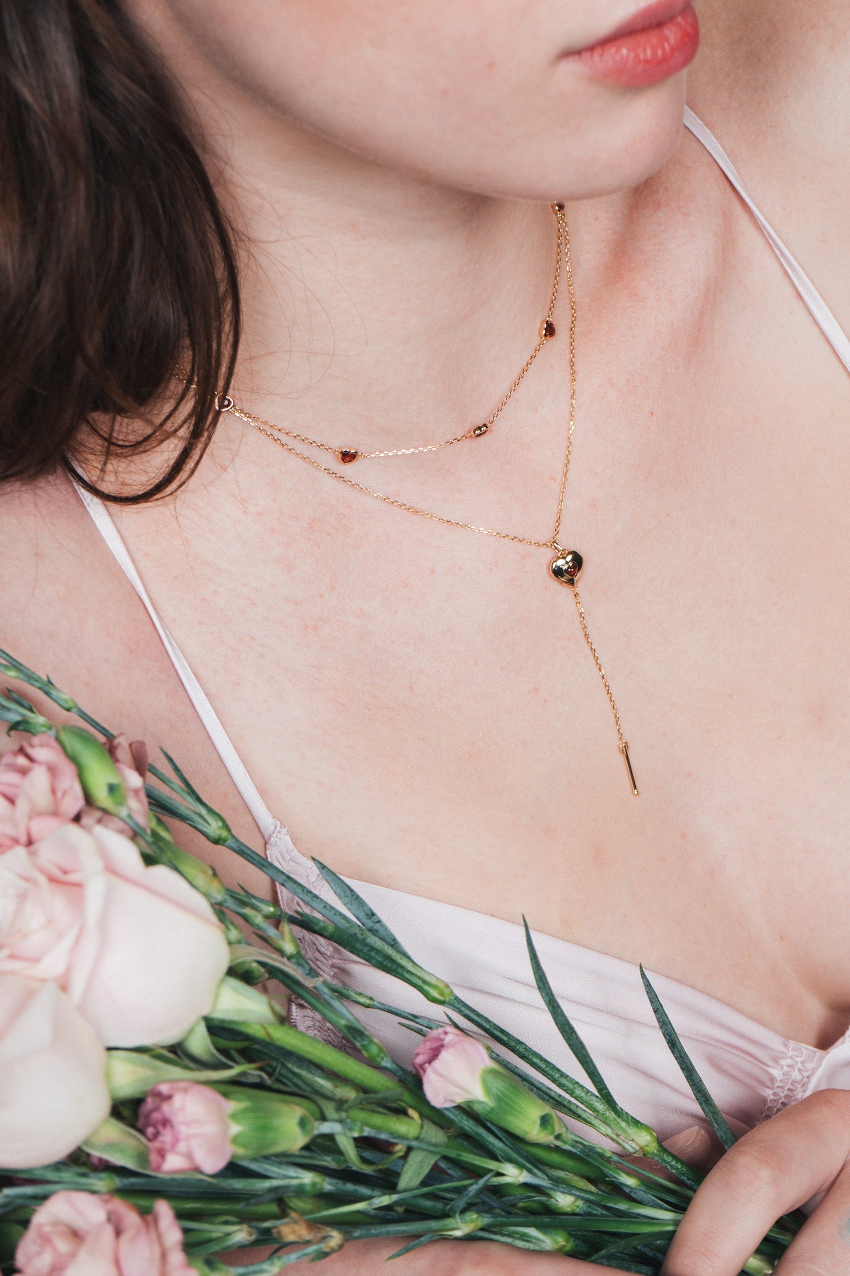 Gold heart charm necklace with removable arrow and red heart garnet center stone