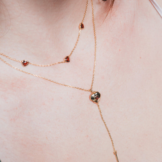 Gold heart charm necklace with removable arrow and red heart garnet center stone