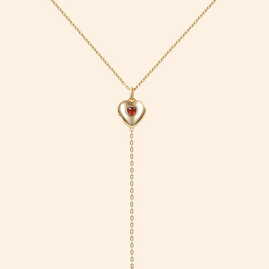 Gold heart charm necklace with removable arrow and red heart garnet center stone
