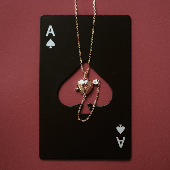 Gold heart charm necklace with removable arrow and red heart garnet center stone