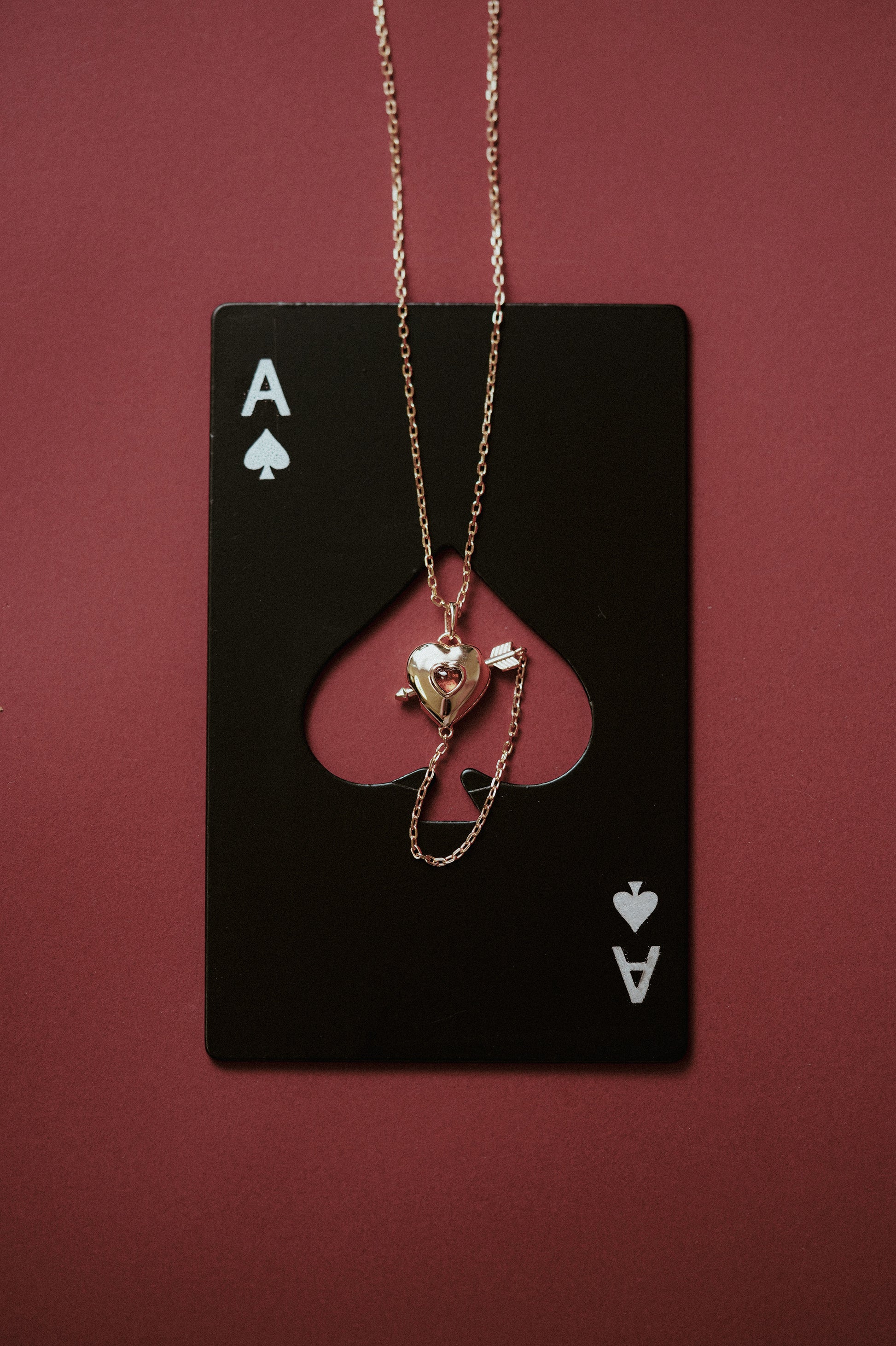 Gold heart charm necklace with removable arrow and red heart garnet center stone