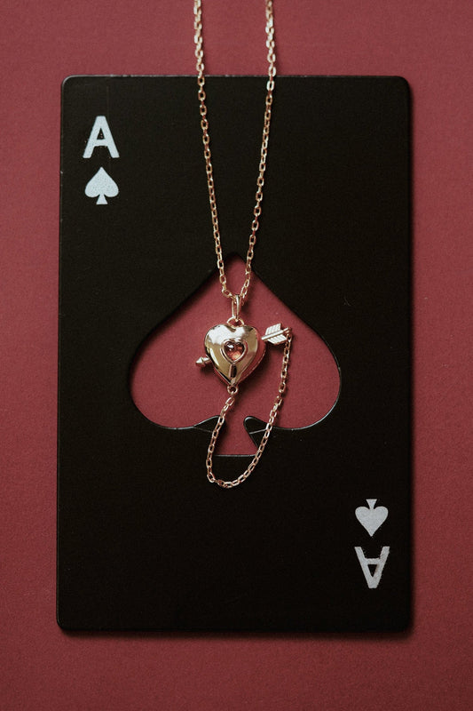 Gold heart charm necklace with removable arrow and red heart garnet center stone
