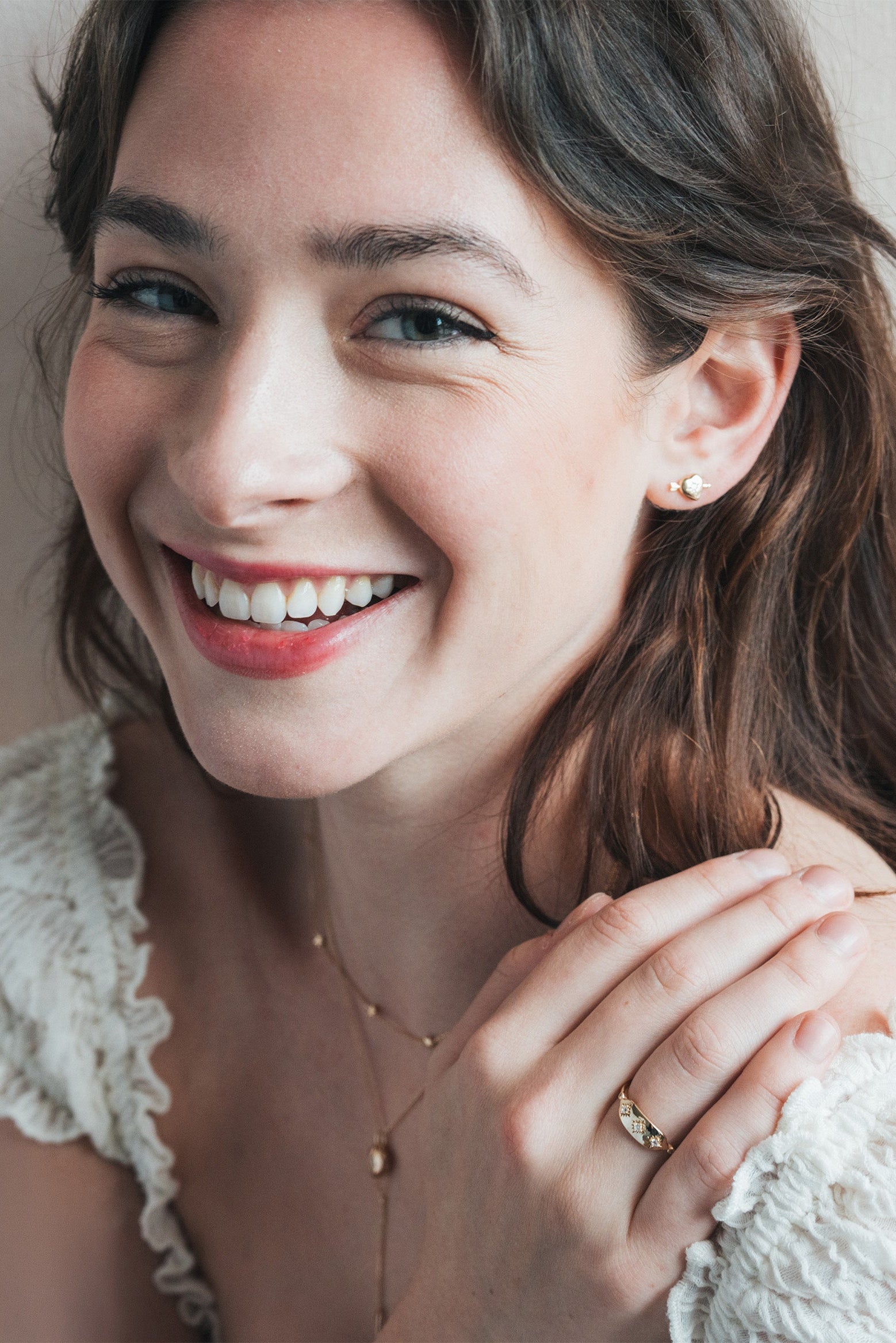 Dainty gold heart stud earrings with arrow details and sparkling center moissanite stones