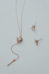 Dainty gold heart stud earrings with arrow details and sparkling center moissanite stones