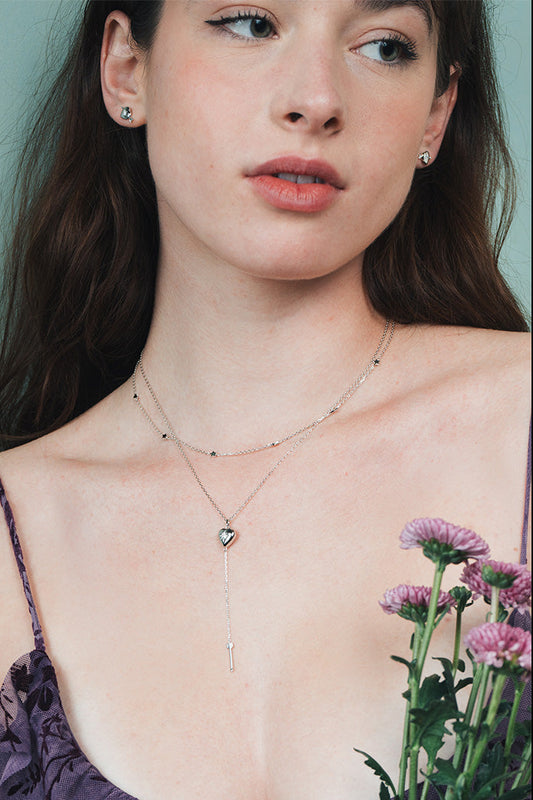 Dainty silver heart stud earrings with arrow details and sparkling center moissanite stones