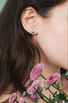 Dainty silver heart stud earrings with arrow details and sparkling center moissanite stones