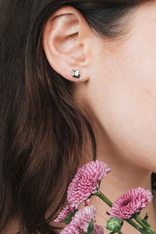 Dainty silver heart stud earrings with arrow details and sparkling center moissanite stones