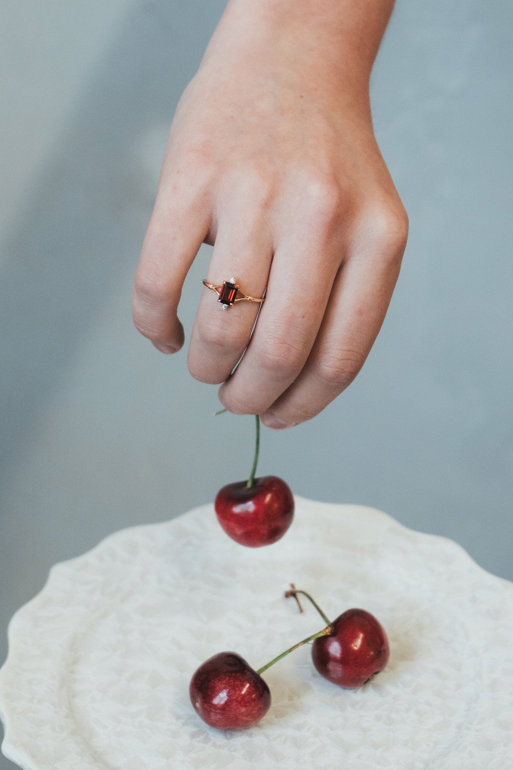 Dainty gold ring with emerald-cut garnet and sparkling moissanite accents