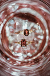 Dainty gold ring with emerald-cut garnet and sparkling moissanite accents