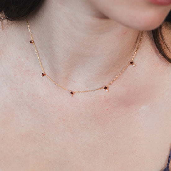 Dainty gold garnet station necklace with sparkling moissanite star accents