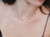 Dainty gold garnet station necklace with sparkling moissanite star accents