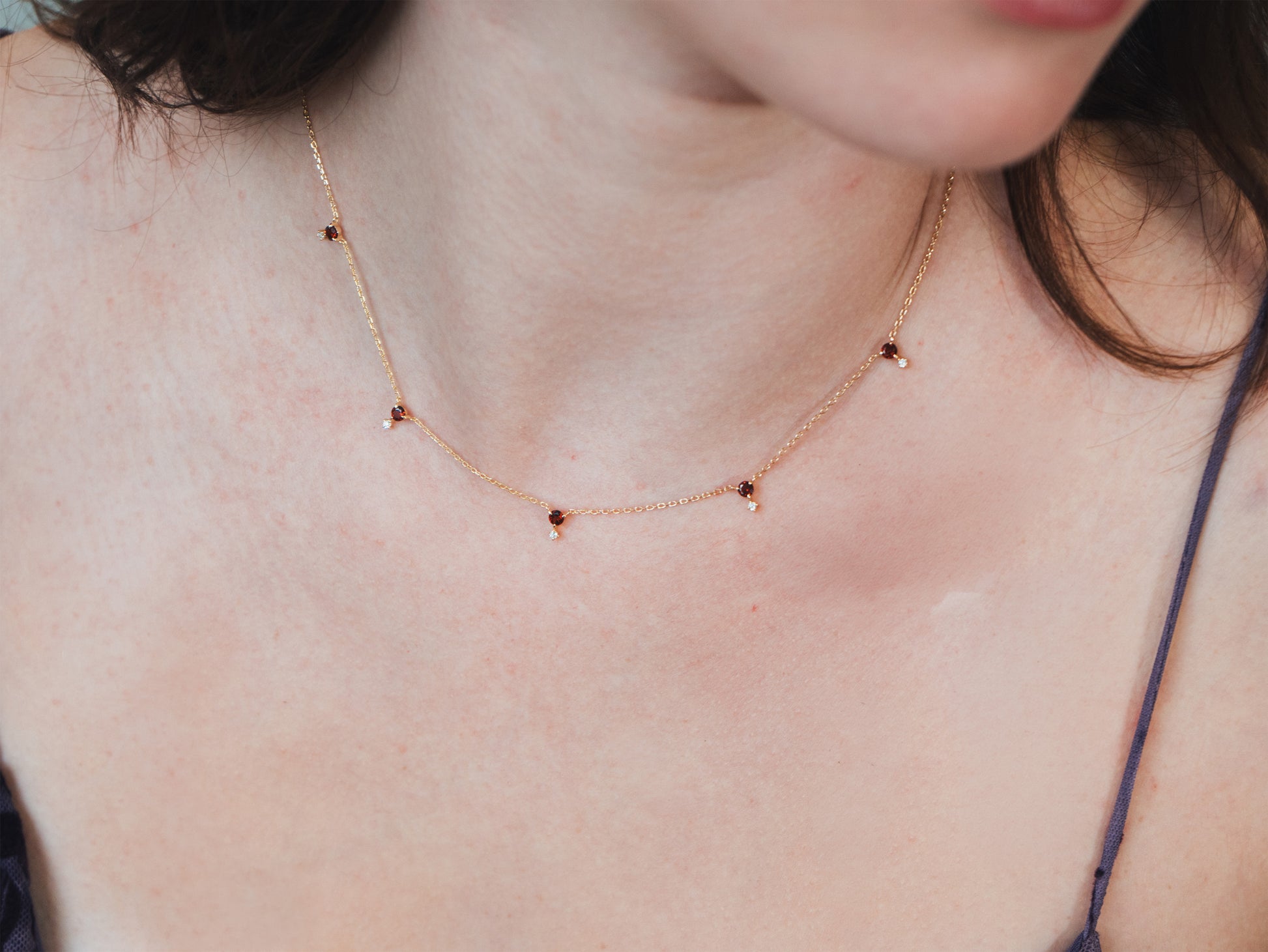 Dainty gold garnet station necklace with sparkling moissanite star accents