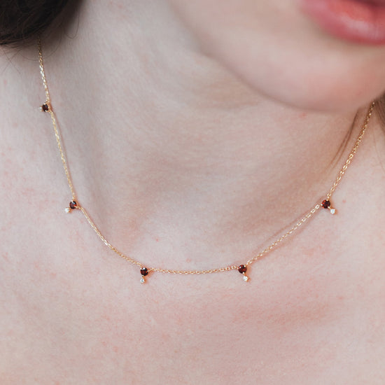 Dainty gold garnet station necklace with sparkling moissanite star accents