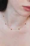 Dainty gold garnet station necklace with sparkling moissanite star accents
