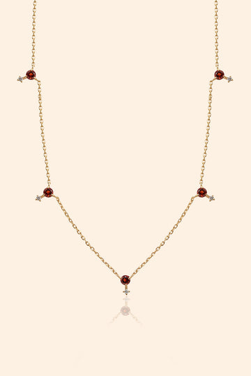 Dainty gold garnet station necklace with sparkling moissanite star accents