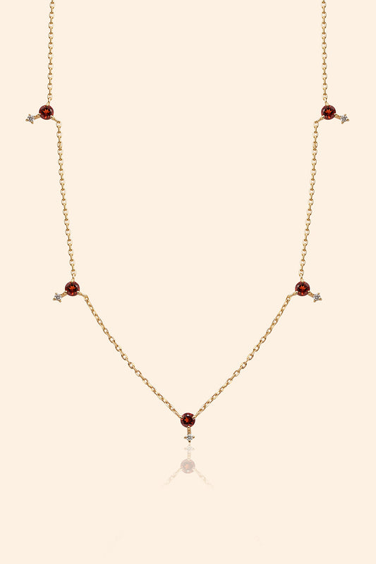 Dainty gold garnet station necklace with sparkling moissanite star accents