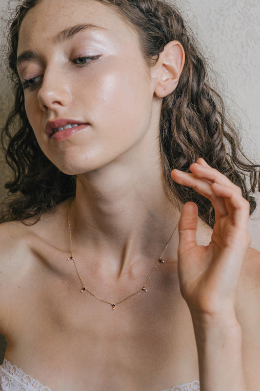 Dainty gold garnet station necklace with sparkling moissanites accents